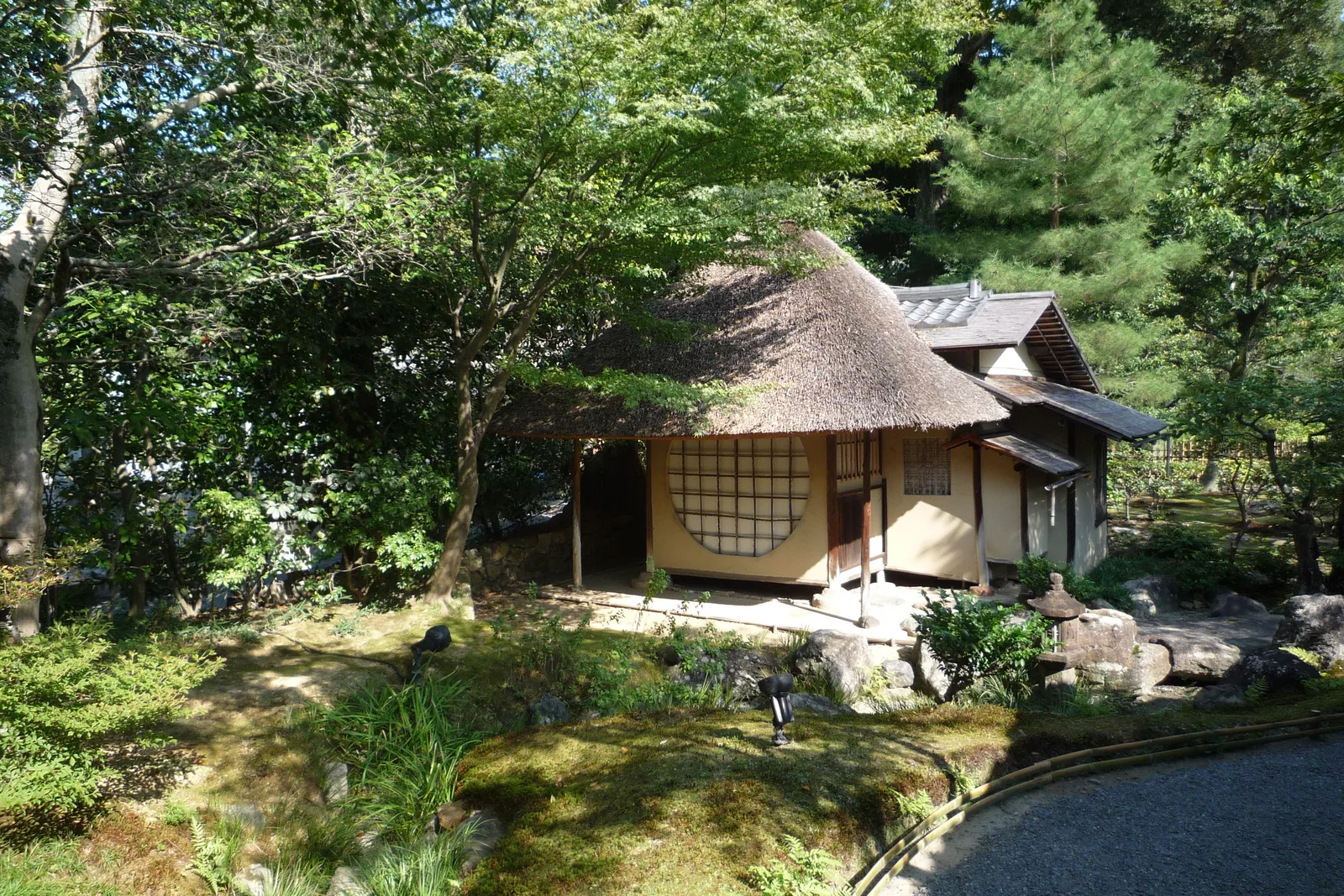 A thatched tea house with a round window among pines and moss in the garden of Kōdai-ji temple, Higashiyama; a general photograph, not of this tea house