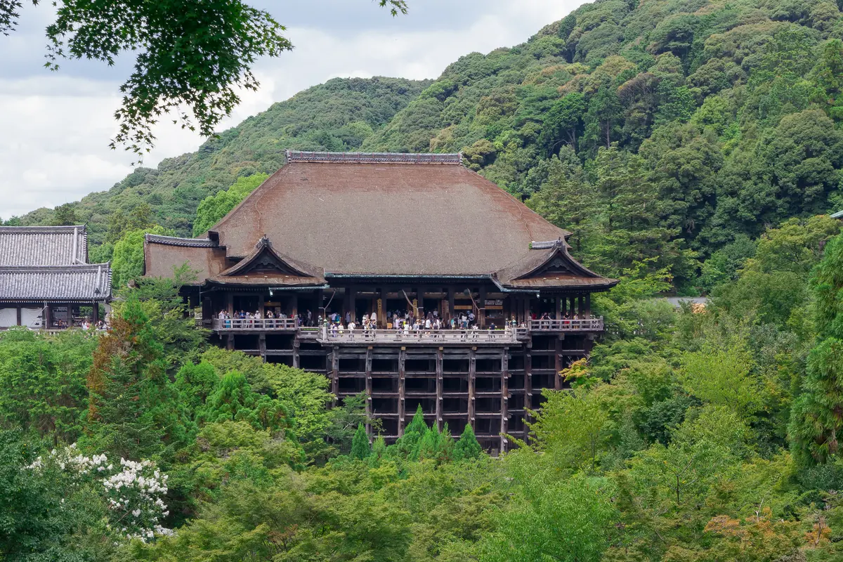 The main hall of Kiyomizu-dera with its wooden veranda seen across a green valley